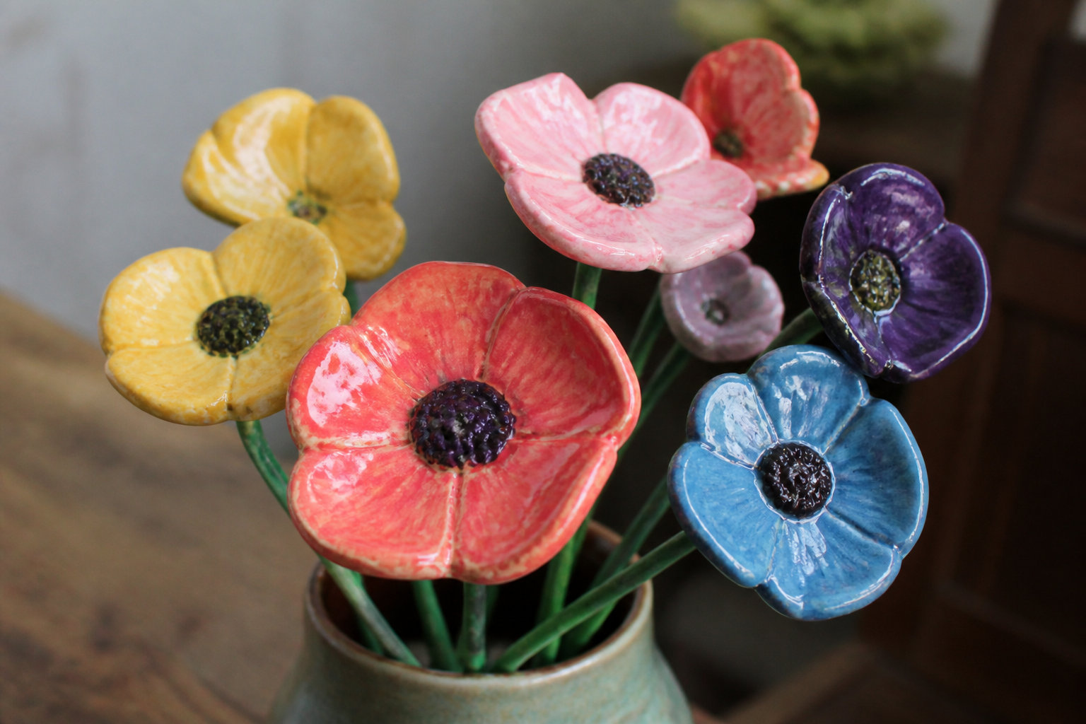 Bouquet de fleurs en argile peintes en jaune, rose, rouge, bleu et violet dans un vase